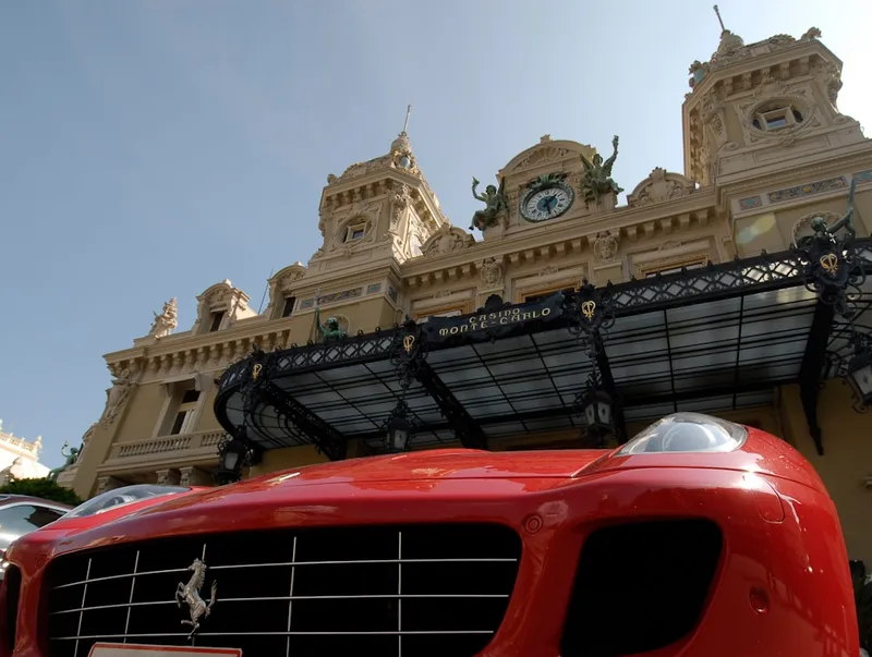 Carro vermelho estacionado em frente a um edificio